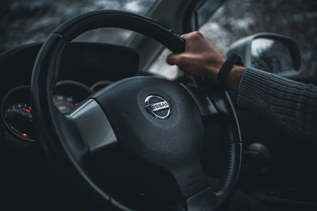 Hand on Nissan steering wheel