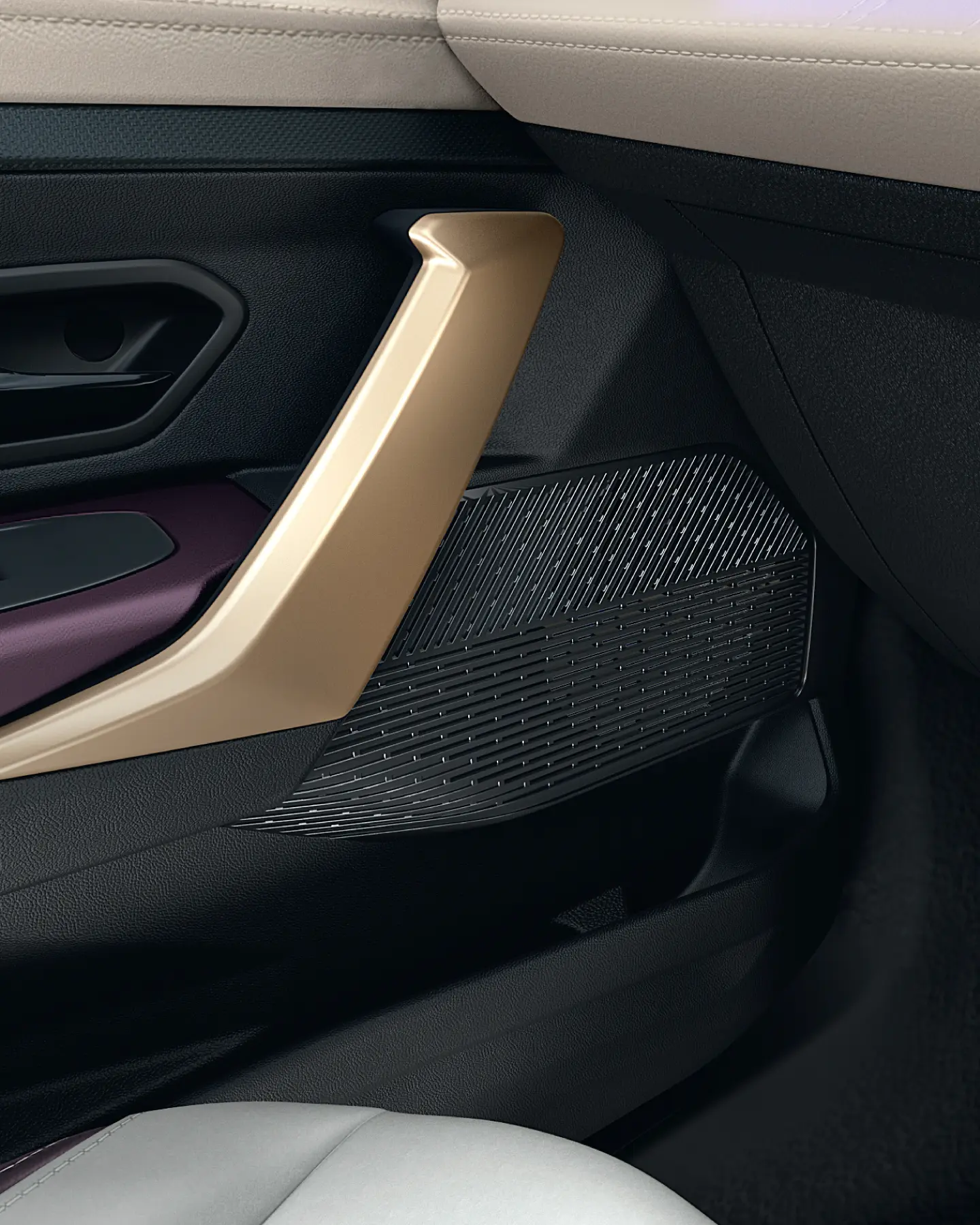 Close-up of a gold car door handle set in a dark interior, with a textured speaker grille below it.